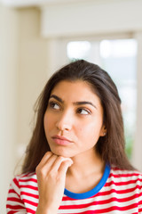 Young beautiful woman thinking and wondering with a hand on chin, doubt concept