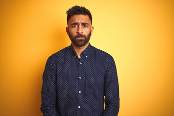 Obraz premium Young handsome indian businessman wearing shirt over isolated yellow background depressed and worry for distress, crying angry and afraid. Sad expression.
