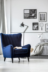 Trendy wing back chair in fancy bedroom interior with elegant furniture