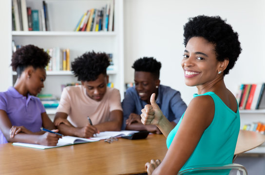 African Mature Tutor With Students At Work