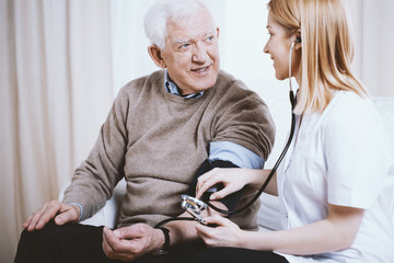 Senior grey man with supporting measuring blood pressure