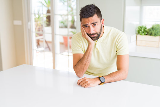 Handsome hispanic man casual yellow t-shirt at home thinking looking tired and bored with depression problems with crossed arms.