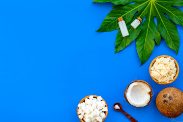 Organic cosmetics with coconut oil on blue background top view mockup
