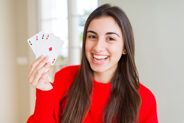 Beautiful young woman gambling playing poker with a happy face standing and smiling with a confident smile showing teeth