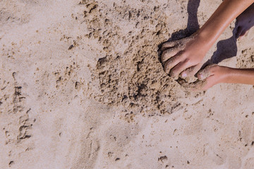 childish hands playing in the sand