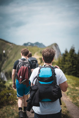 Hiking people or hikers hiking up the benediktenwand mountain in bavaria germany in the alps with motivationa and backpacks