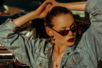 Outdoor close up fashion portrait of young beautiful fashionable woman wearing red cat eye...