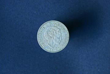 one old white denmark coin on blue background