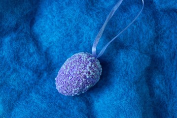 one lilac plastic egg toy lies on blue fur