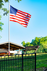 American flag by bench with beautiful sky
