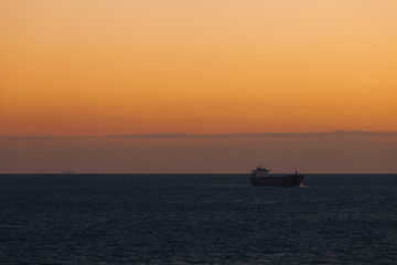 Ship sailing in the Mediterranean sea at sunset