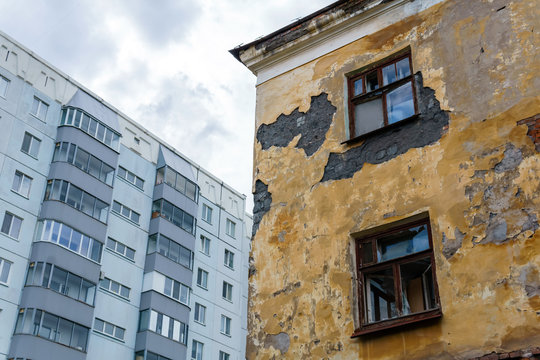 abandoned house on the background of a modern apartment building