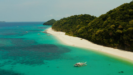 Aerial seascape: Tropical beach with palm trees and turquoise waters of the coral reef, from above, Puka shell beach. Boracay, Philippines. Seascape with beach on tropical island. Summer and travel