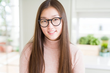 Beautiful Asian woman wearing glasses with a happy and cool smile on face. Lucky person.