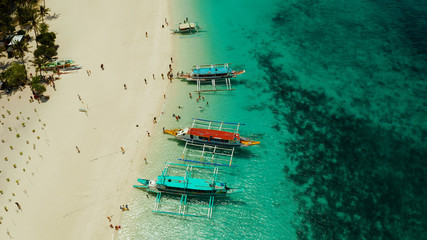 Tropical landscape: Sandy beach with palm trees and turquoise waters of the coral reef top view, Puka shell beach. Boracay, Philippines. Seascape with beach on tropical island. Summer and travel