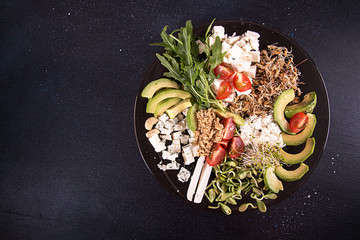 Healthy vegetarian salad of avocado, cherry tomato, sprouts, arugula, feta; blue cheese, cereals. Healthy eating food.