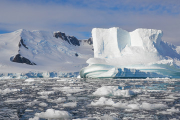 Close up of iceberg shaped by water surrounded by melting ice