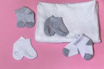 Baby socks for newborn girl or boy collected on a pink background, pregnancy and baby shower concept