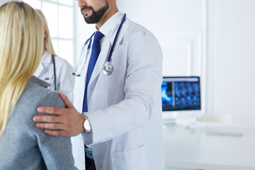 Handsome male doctor consulting a couple about infertility in his medical office