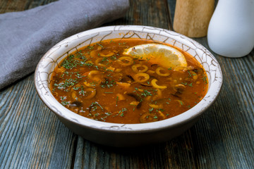 Meat Solyanka soup on blue wood table