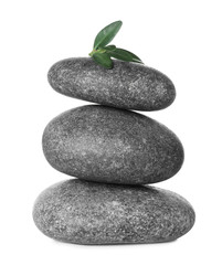Stack of grey spa stones and fresh leaves isolated on white