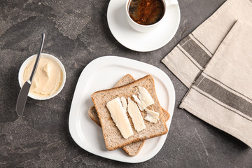 Flat lay composition with bread and butter served on grey table