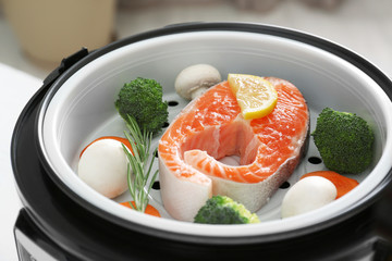 Salmon steak with garnish in multi cooker, closeup