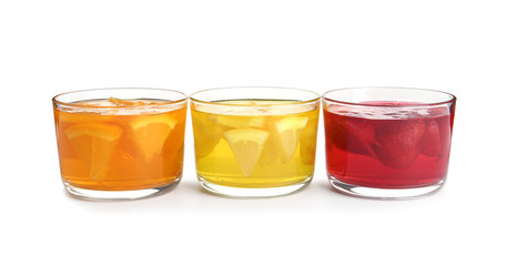 Tasty jelly desserts in glasses on white background