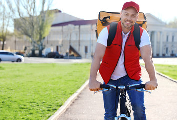 Male courier on bicycle delivering food in city