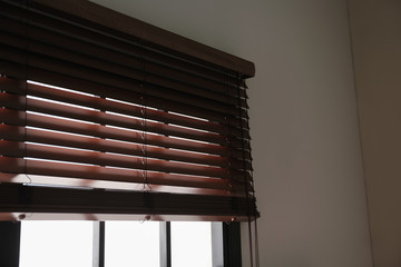 Modern window with stylish wooden blinds indoors