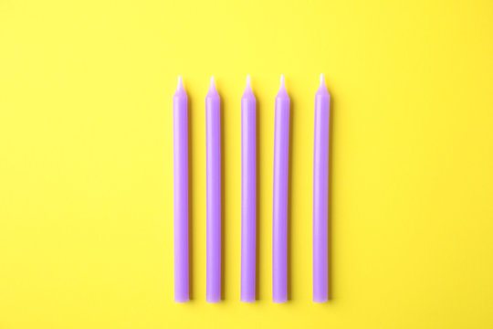 Purple Birthday Candles On Yellow Background, Top View