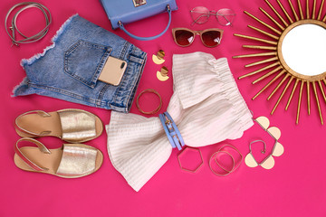 Flat lay composition with stylish summer clothes and accessories on pink background