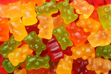 Delicious bright jelly bears as background, top view