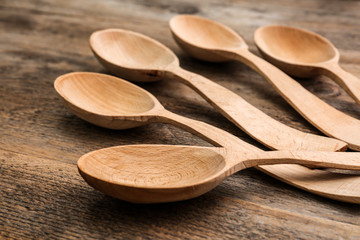 Clean empty spoons on wooden background, closeup