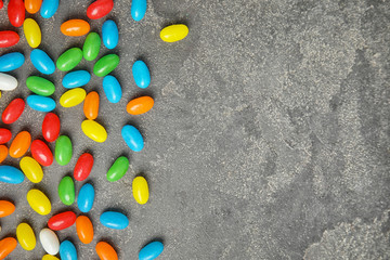 Flat lay composition with jelly beans on stone background. Space for text