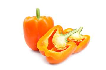 Whole and cut orange bell peppers on white background
