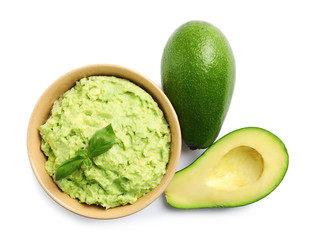 Bowl of tasty guacamole with basil and avocados on white background, top view