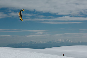 Snow kite surfing in winter mountains.