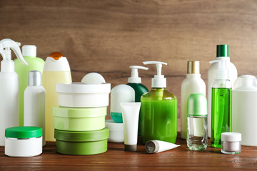 Different body care products on table against wooden background