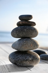 Fototapeta na wymiar Stack of stones on wooden deck outdoors. Zen concept