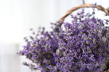 Fresh lavender flowers in basket on blurred background, closeup. Space for text