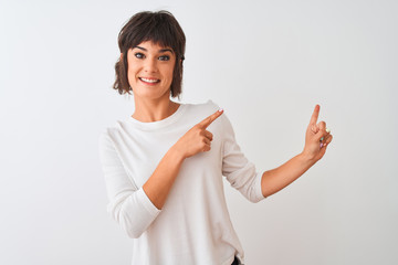 Fototapeta premium Young beautiful woman wearing casual t-shirt standing over isolated white background smiling and looking at the camera pointing with two hands and fingers to the side.