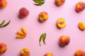 Flat lay composition with fresh peaches on pink background