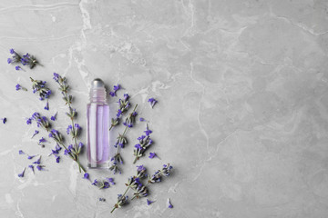 Flat lay composition with natural lavender essential oil on marble table, space for text