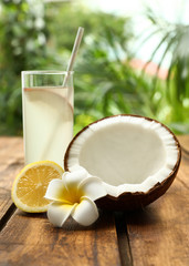 Composition with glass of coconut water and lemon on wooden table