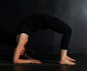 Fototapeta na wymiar Young white woman does yoga poses in a studio. 