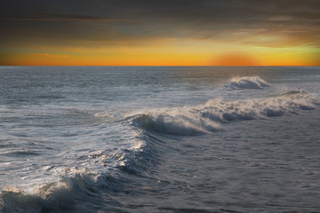 Fototapeta na wymiar Big ocean wave at orange sunset
