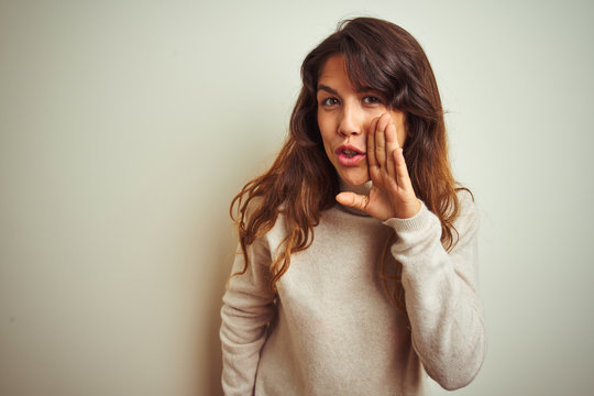 Young Beautiful Woman Wearing Winter Sweater Standing Over White Isolated Background Hand On Mouth Telling Secret Rumor, Whispering Malicious Talk Conversation