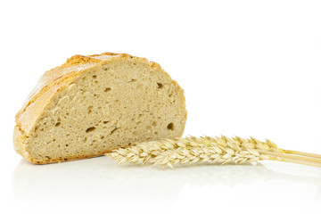 One half of fresh baked rye wheat bread with three golden wheat ears isolated on white background