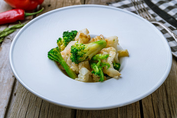 broccoli fried with onions on wooden background